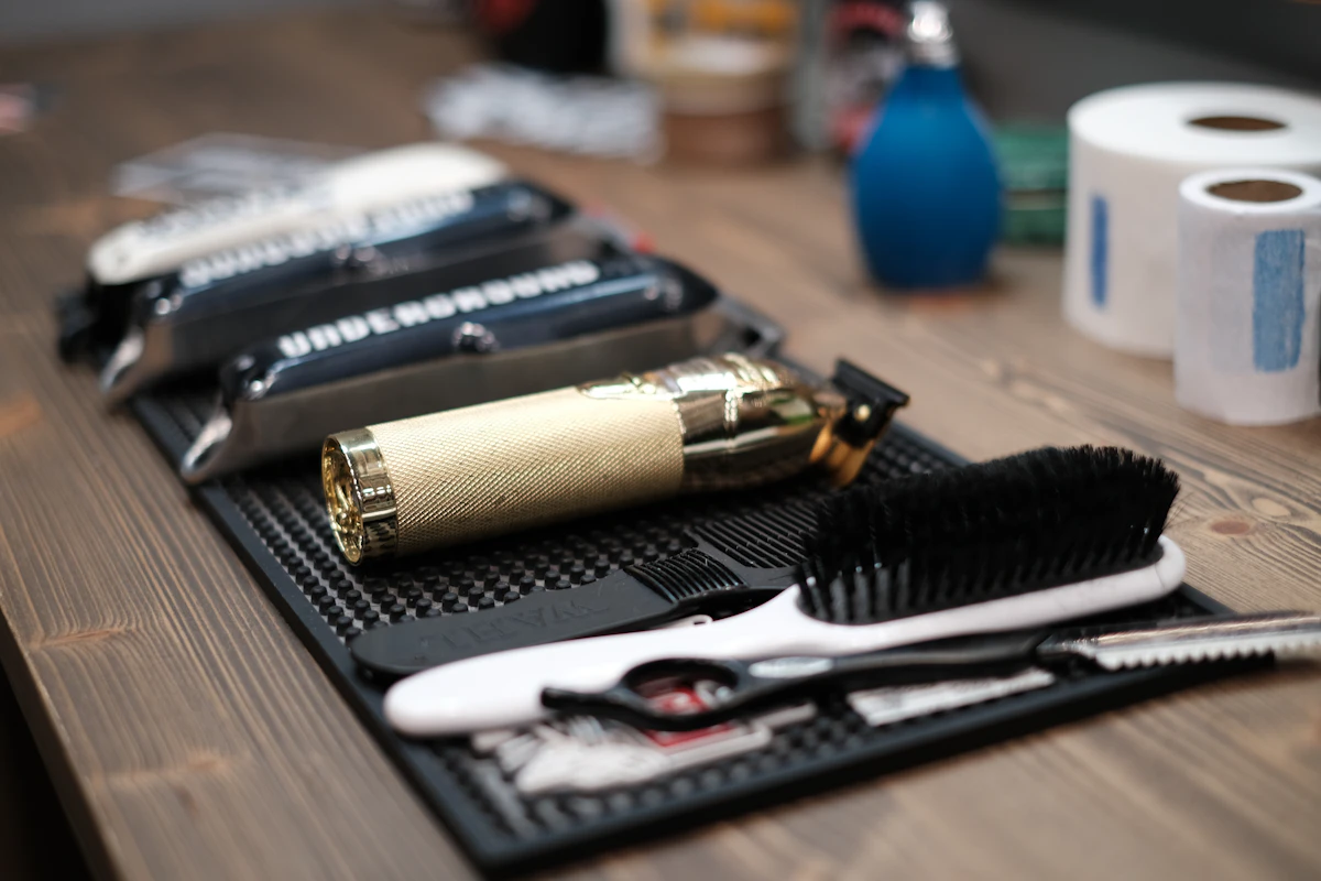 Outils du barbier disposés sur le comptoir : ciseaux, peigne, brosse